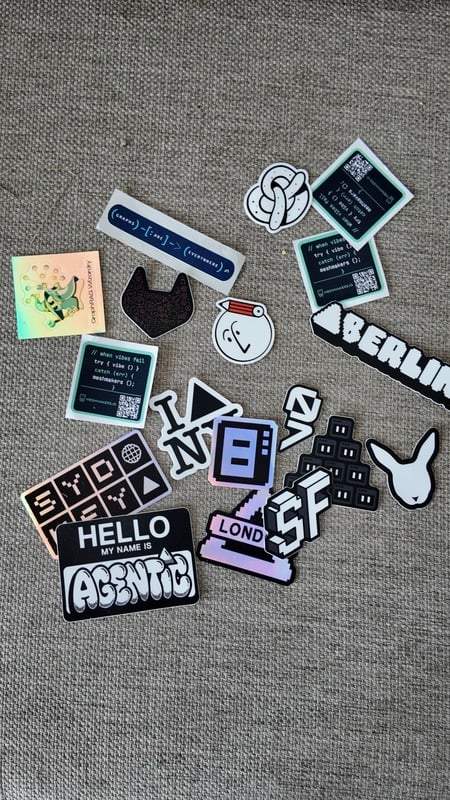 A scattered pile of laptop stickers on a desk
